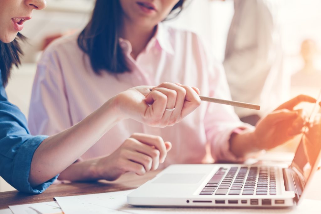 Two UK marketing executives reviewing content on a laptop